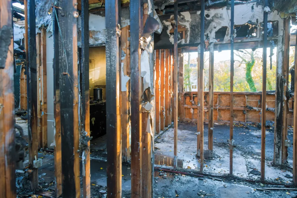 Exposed interior wall framing and damaged finishes following a house fire