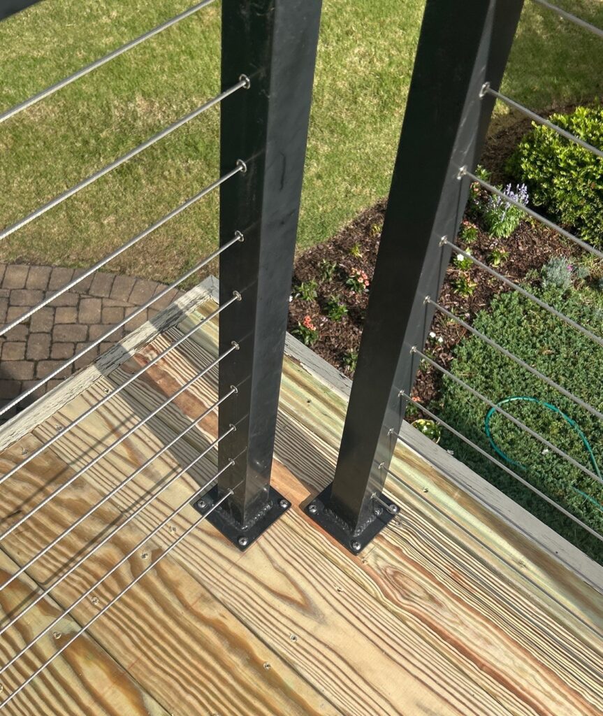 Cable railing and dark posts beside the wood deck boards in Southport, NC