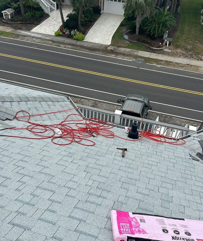 Shingle installation with tools and materials on the roof in Ocean Isle Beach, NC