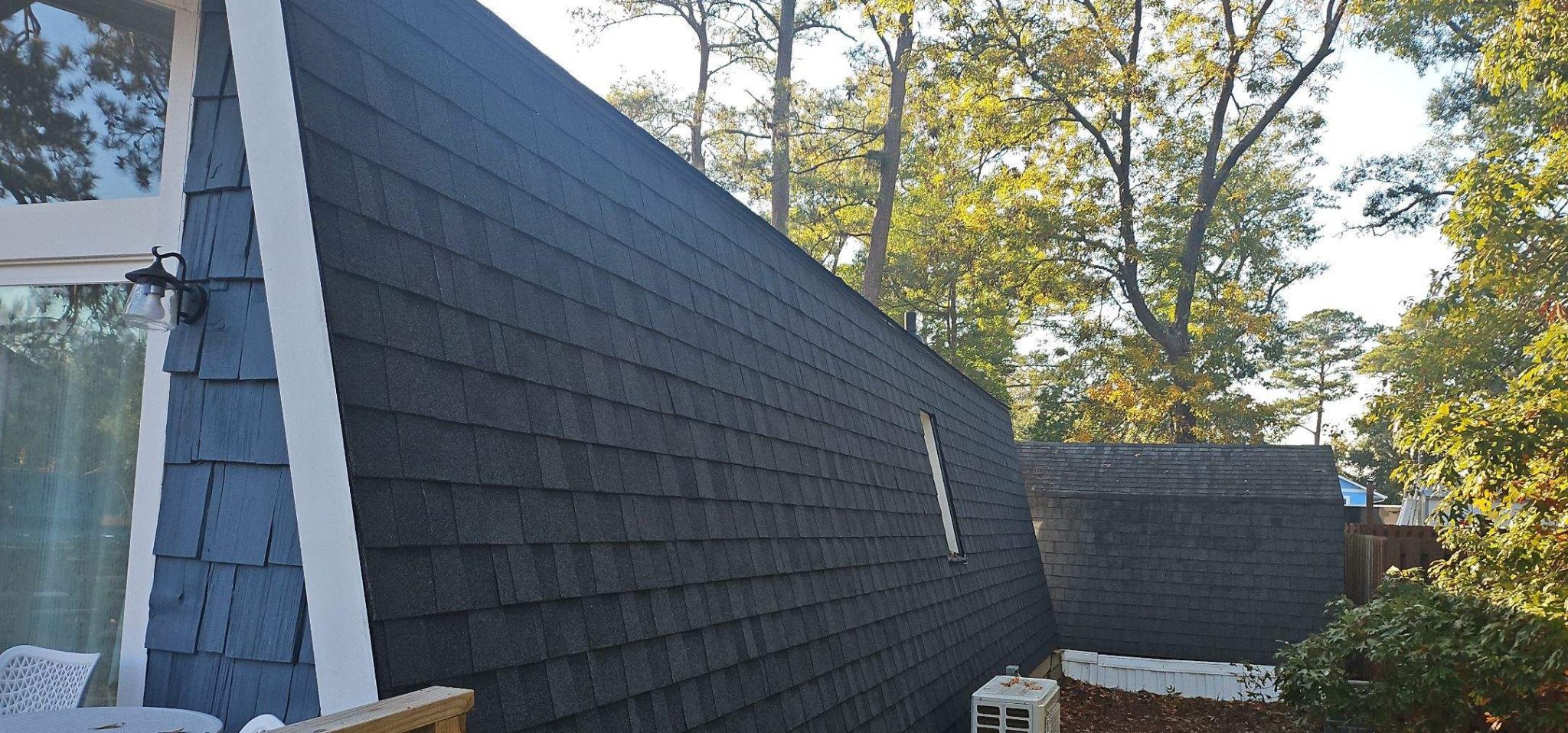 Dark shingles on the steep mansard roof section in Oak Island, NC