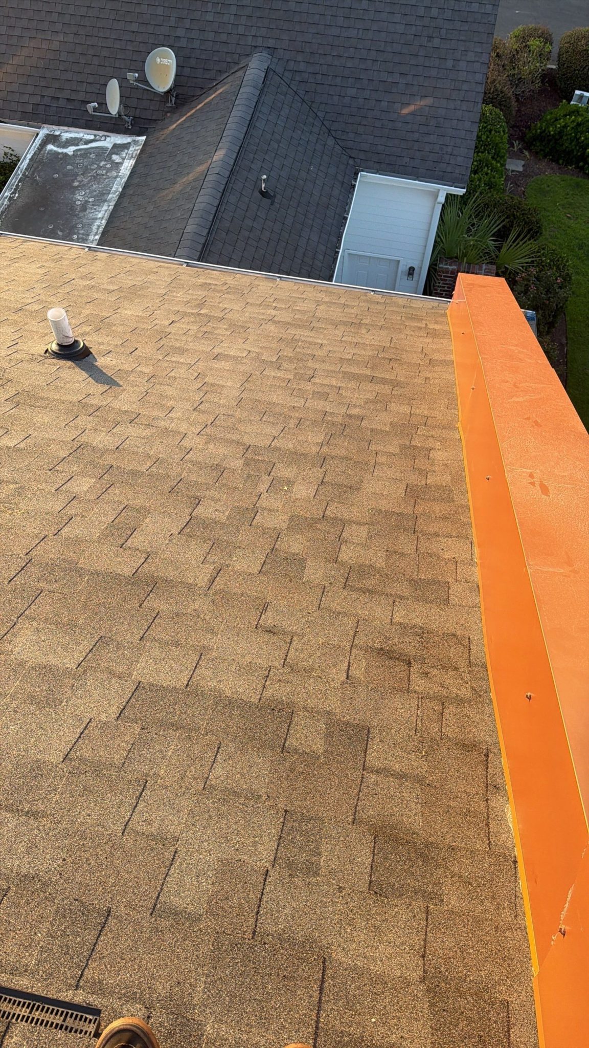 Townhome roof decking exposed beside orange roof-edge trim in Sunset Beach, NC