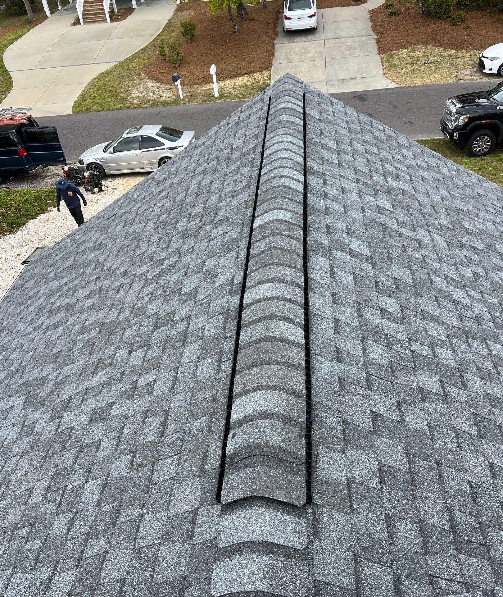 Installed architectural shingles along the roof ridge in Oak Island, NC