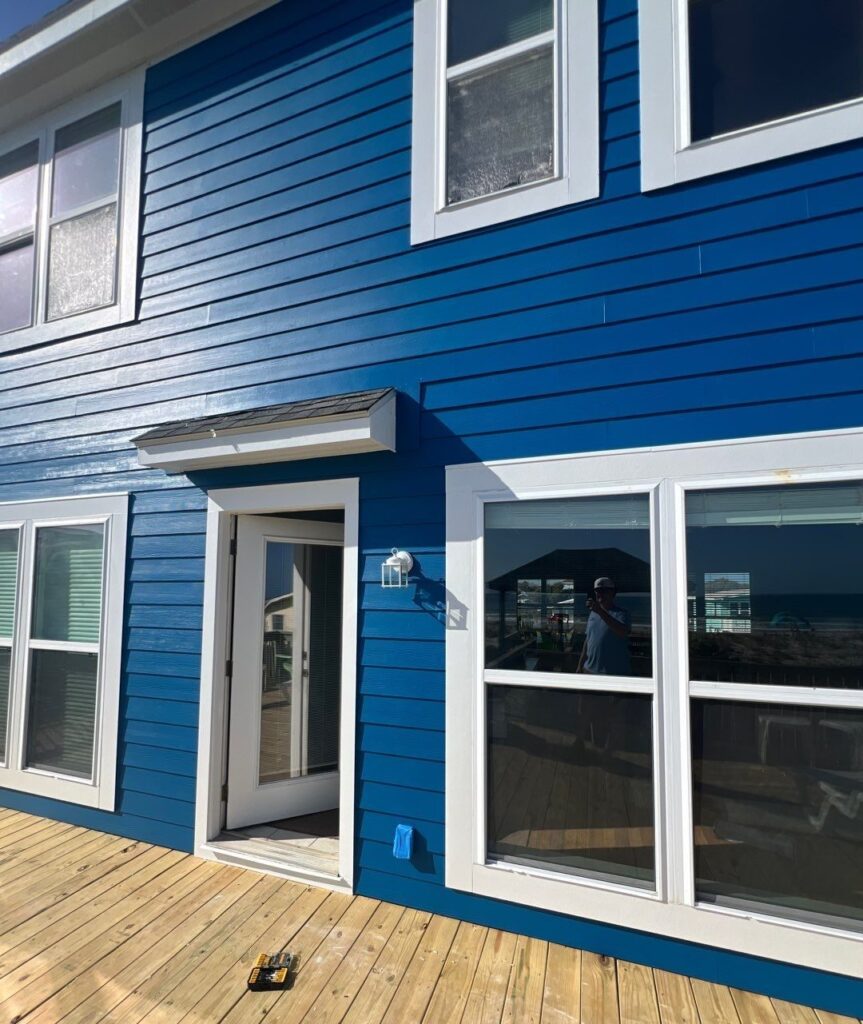 Blue exterior siding and white trim around glazed doors in Oak Island, NC