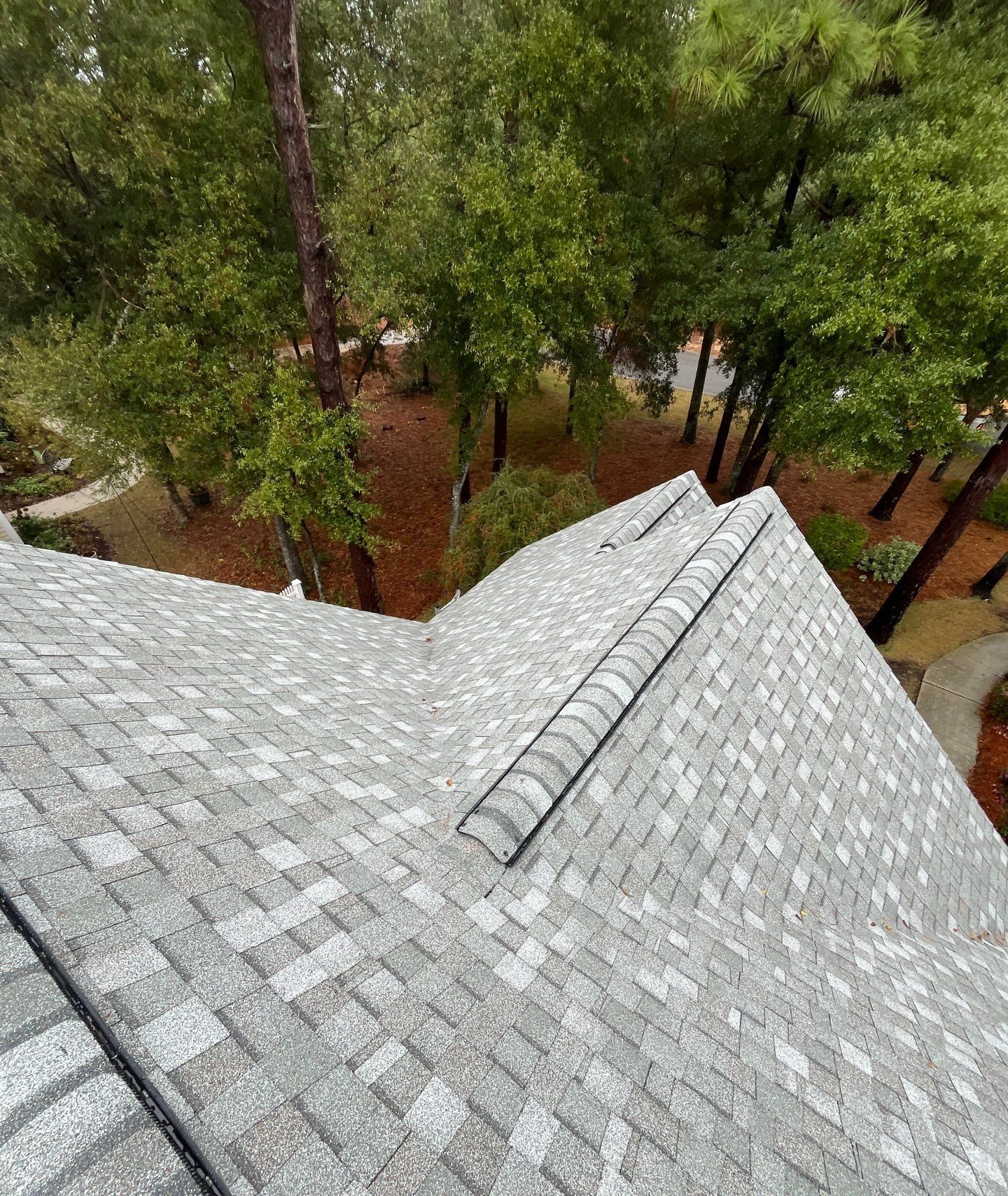Shingle ridge junction with trees beyond in Oak Island, NC