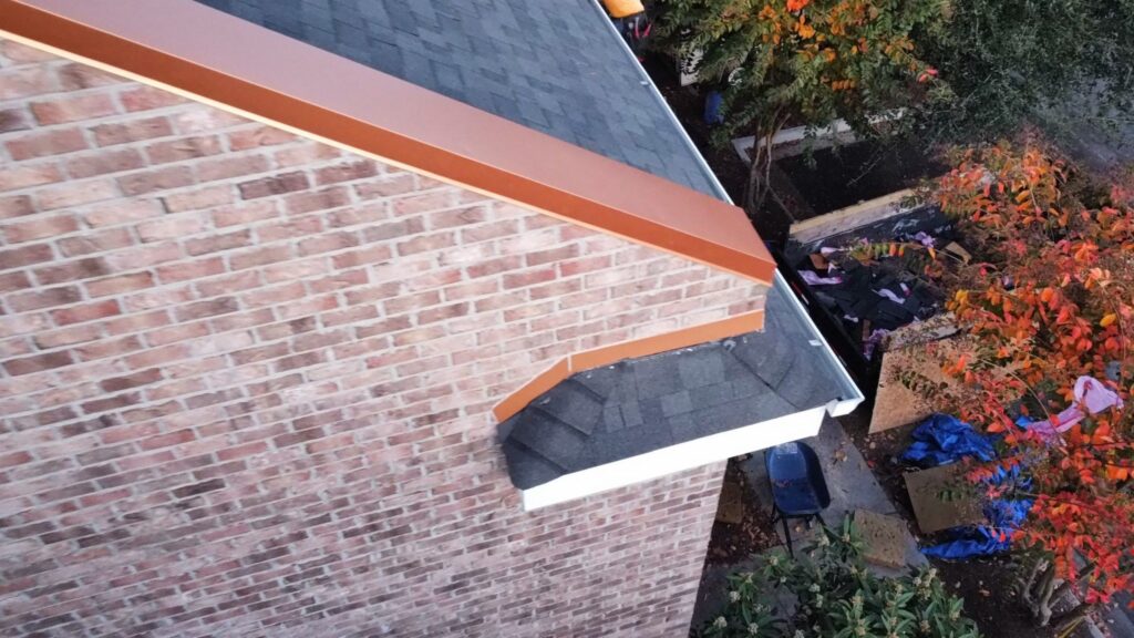 Shingle courses and metal trim at the brick townhome roof edge in Sunset Beach, NC