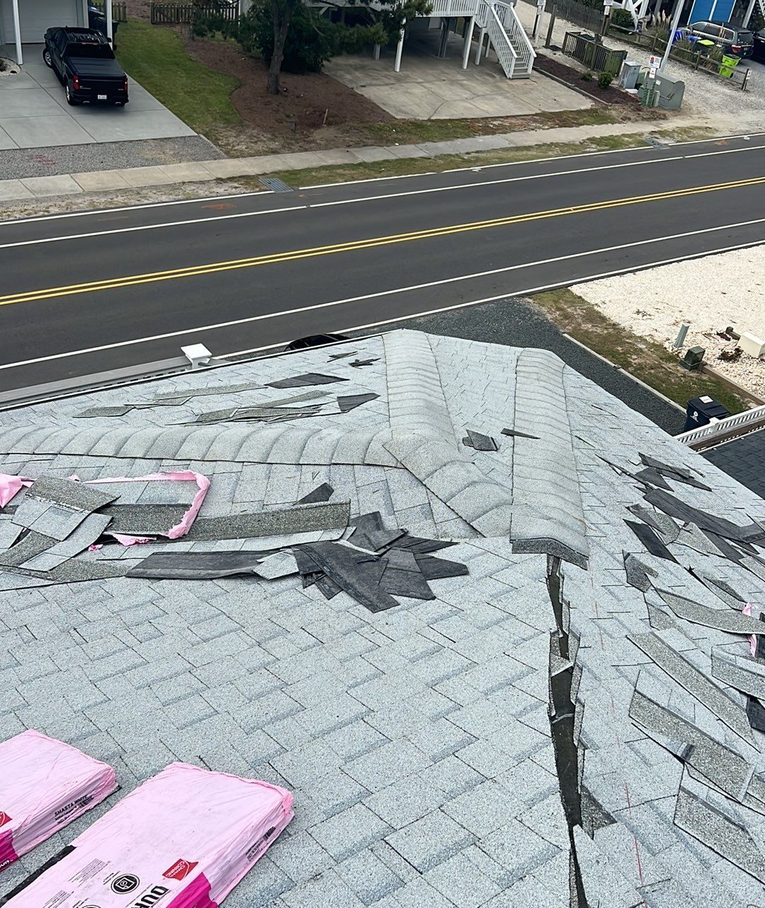Roof ridge with staged shingles and installation tools in Ocean Isle Beach, NC