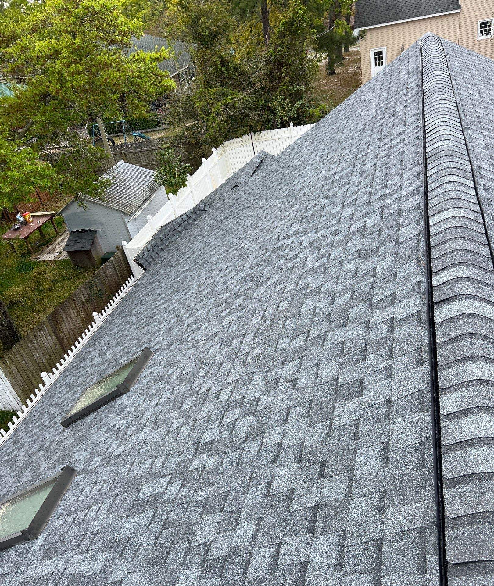 Roof slope with skylight and newly installed shingles in Oak Island, NC