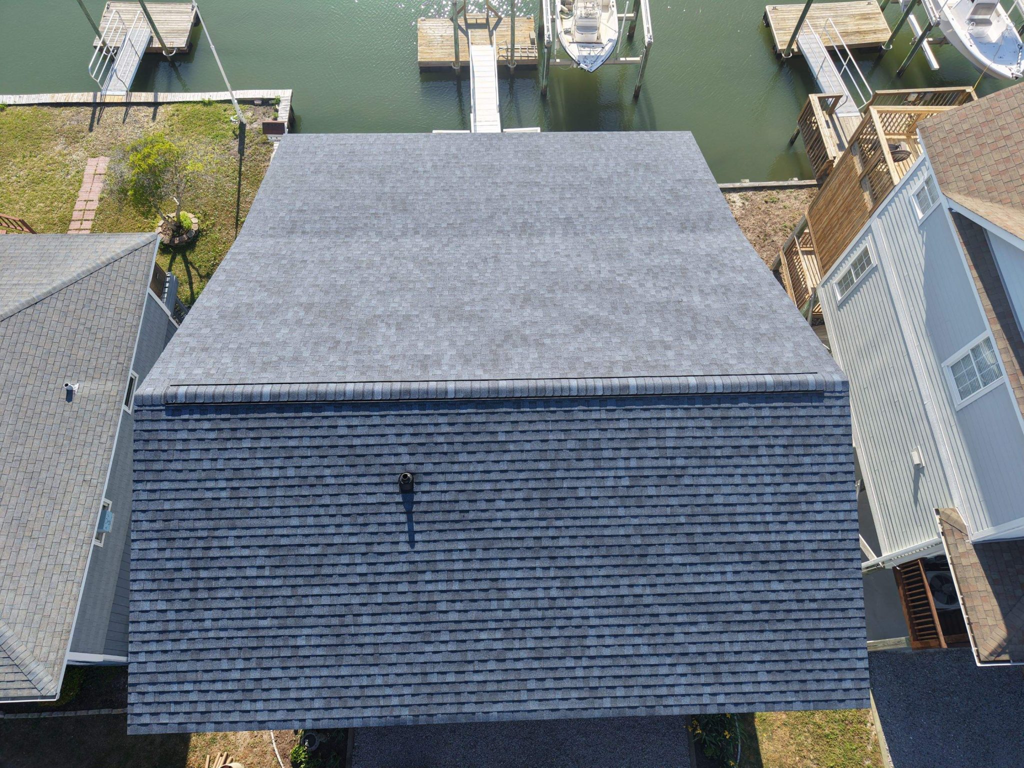 Overhead view of the new shingle roof planes and finished ridge caps on the same Holden Beach home