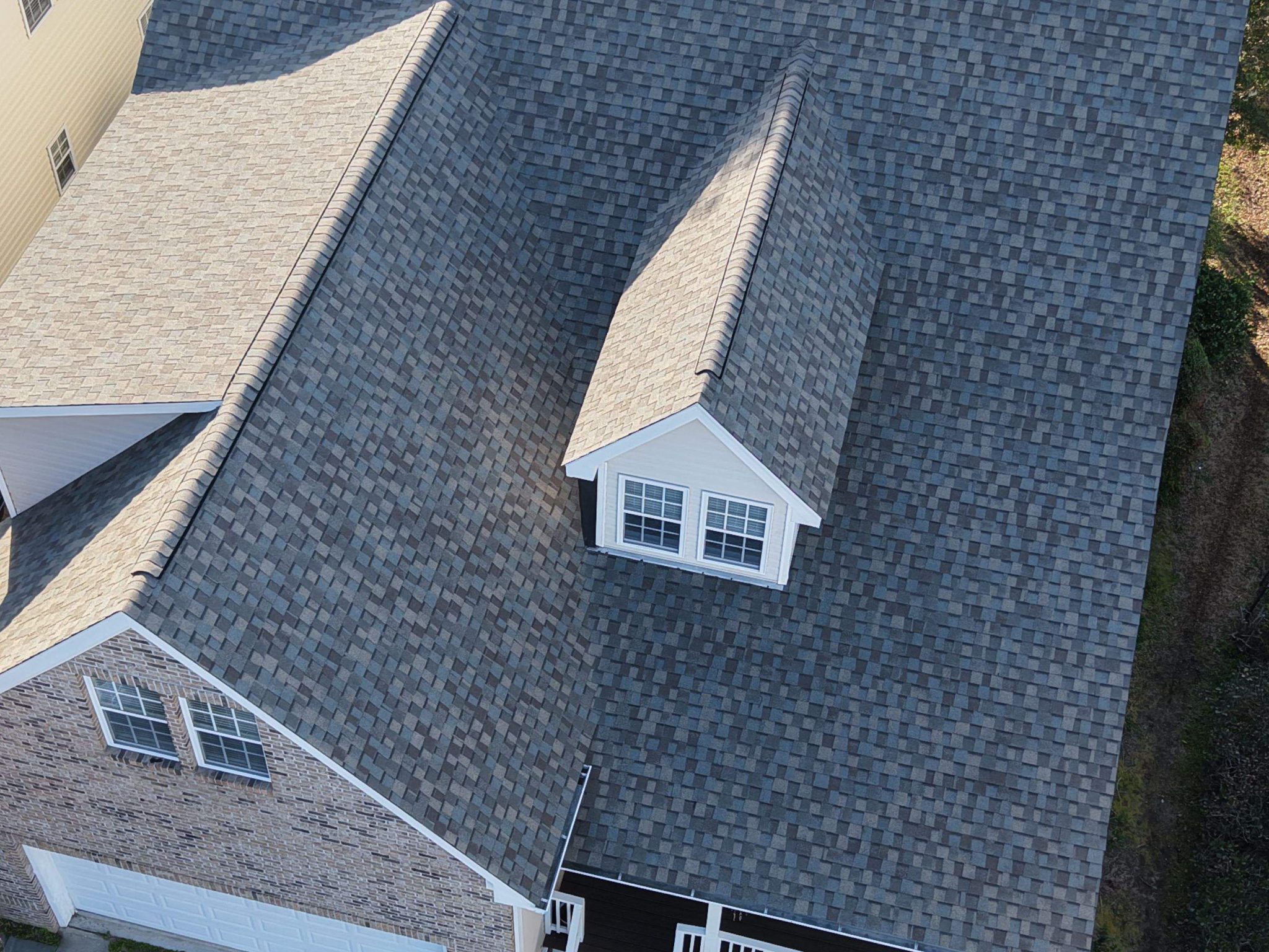 Steep shingle roof planes surrounding the dormer in Southport, NC