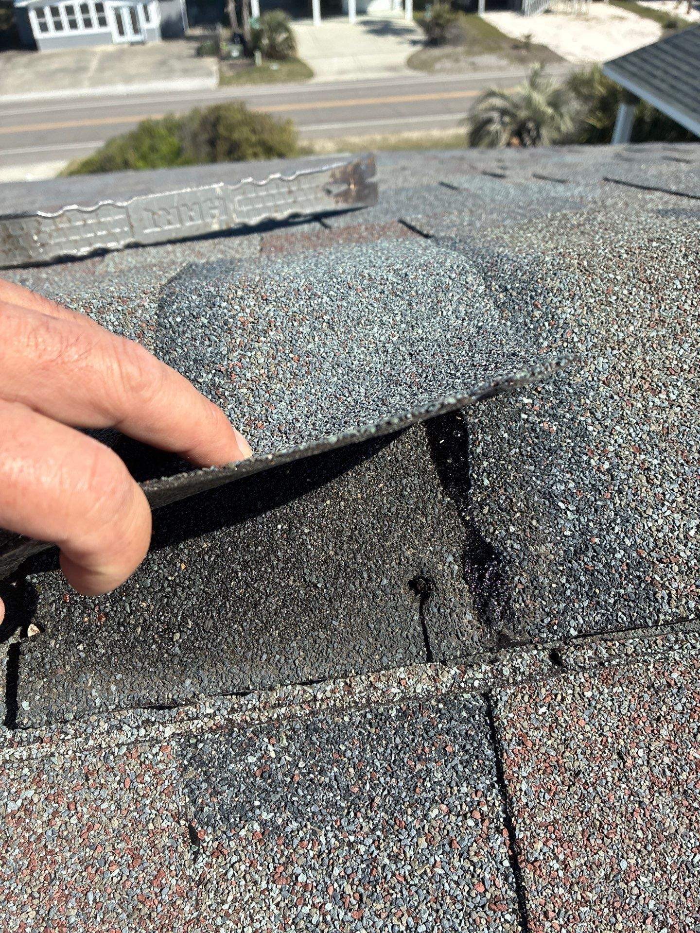 Lifted ridge shingle showing the fastening area in Oak Island, NC