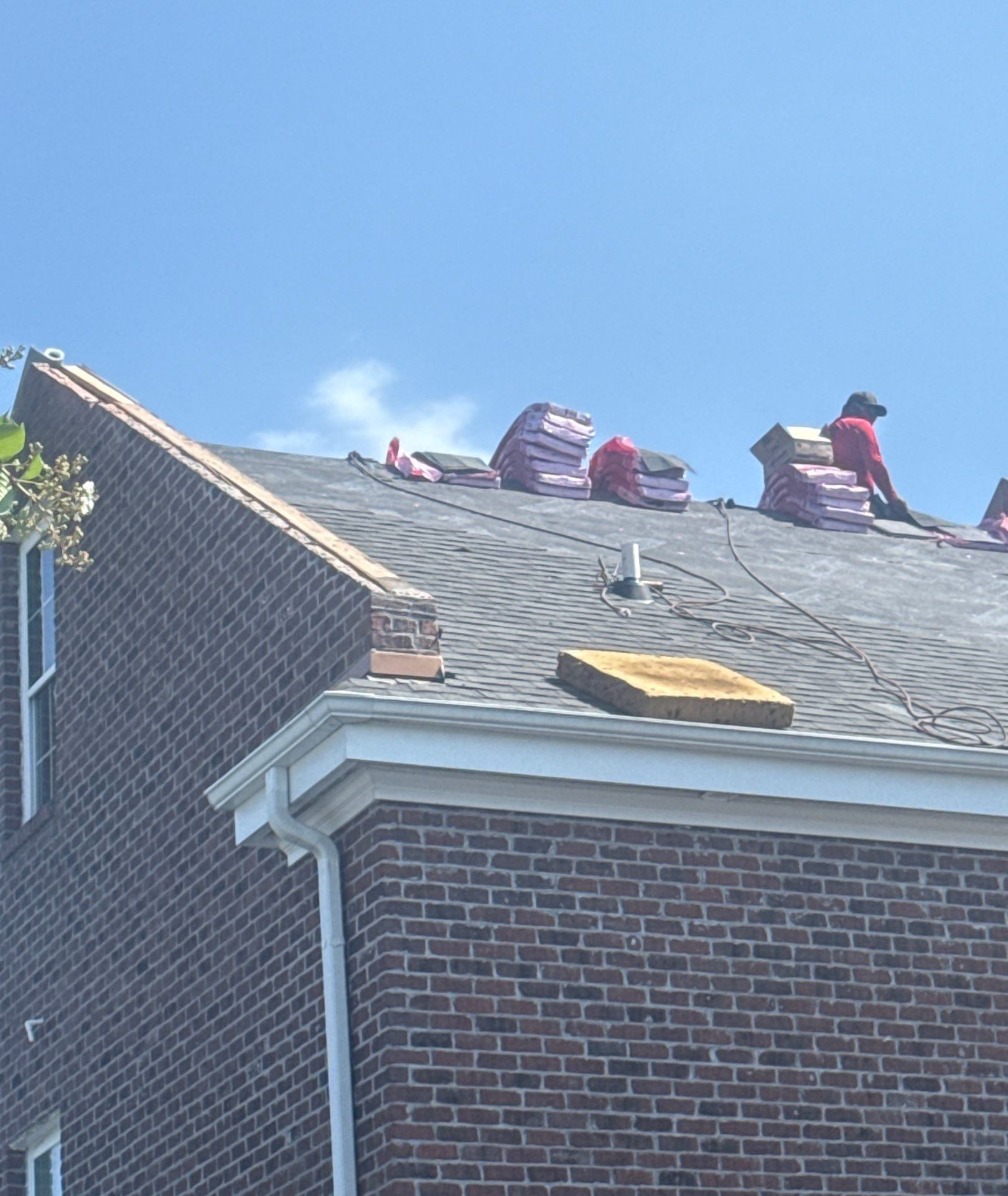 Roofing materials staged above the brick townhome wall in Sunset Beach, NC